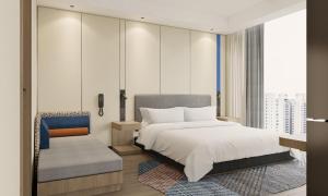a bedroom with a king sized bed and a chair at Holiday Inn Express Xi'an Daxing by IHG in Xi'an