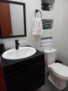 カラルカにあるCasahotelnapolesの洗面台、トイレ、鏡のあるバスルーム