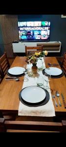 a wooden table with plates and glasses on it at Departamento Santa Teresita in Villa Unión