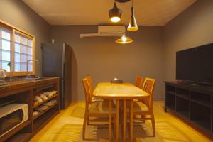 a kitchen with a table and chairs and a refrigerator at 静響の宿 Silent Echo Inn in Osaka