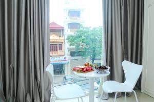 a table with a bowl of fruit next to a window at Noibai Ville Hotel & Travel in Noi Bai