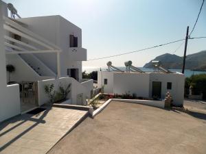 a white house with a driveway in front of it at Aspous Studios and Rooms in Skiros
