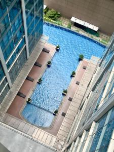 an overhead view of a large swimming pool in a building at Cozy 1BR Condo with Uptown Mall View - BGC Zen Suite in Manila