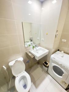 a white bathroom with a toilet and a sink at Cozy 1BR Condo with Uptown Mall View - BGC Zen Suite in Manila