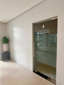 a door to a building with a potted plant next to it at Cozy 1BR Condo with Uptown Mall View - BGC Zen Suite in Manila