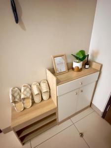 a room with a shelf and a cabinet with a plant at Cozy 1BR Condo with Uptown Mall View - BGC Zen Suite in Manila