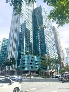 a tall building with cars parked in front of it at Cozy 1BR Condo with Uptown Mall View - BGC Zen Suite in Manila +27 photos