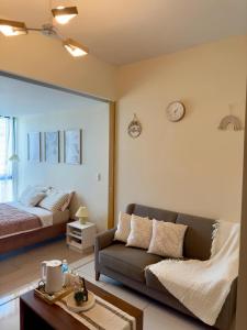 a living room with a couch and a bed at Cozy 1BR Condo with Uptown Mall View - BGC Zen Suite in Manila