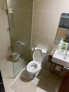a bathroom with a toilet and a shower and a sink at Cozy 1BR Condo with Uptown Mall View - BGC Zen Suite in Manila