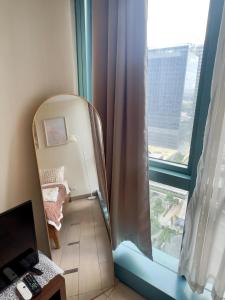 a room with a window with a chair and a mirror at Cozy 1BR Condo with Uptown Mall View - BGC Zen Suite in Manila