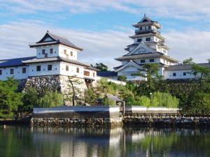 two japanese castles next to a body of water at 汐の丸 in Imabari