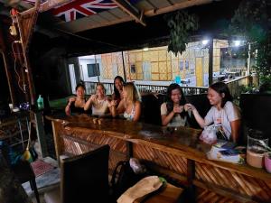 a group of women sitting at a bar at The Backyard Inn in Moalboal
