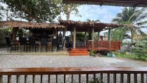 a wooden gazebo with chairs and a table at The Backyard Inn in Moalboal