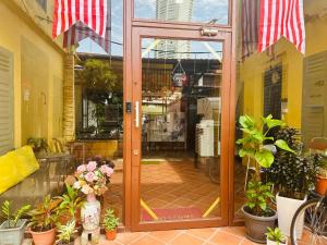 an open glass door of a store with plants at The Century Aigoh Hotel in George Town