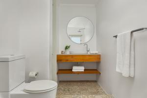 une salle de bain avec un lavabo et un miroir dans l'établissement Neighbourgood Romney, au Cap 36 autres photos