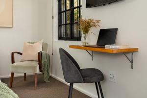 une chaise et un bureau avec un ordinateur portable sur un mur dans l'établissement Neighbourgood Romney, au Cap