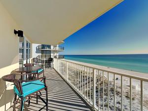 a balcony with tables and chairs and the beach at Sea Dunes #401 in Fort Walton Beach