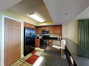 a kitchen with a black refrigerator freezer next to a door at Sea Dunes #401 in Fort Walton Beach