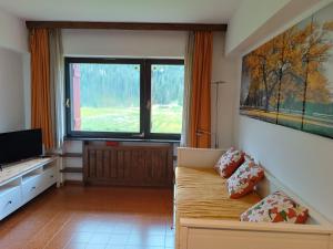 a living room with a couch and a large window at Casa Emma in Ecche +5 photos