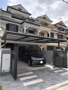 a car parked in a garage in front of a house at Homestay Last World Tambun in Kampong Batu Lapan