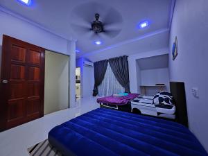 a blue bedroom with a bed and a ceiling at Homestay Last World Tambun in Kampong Batu Lapan