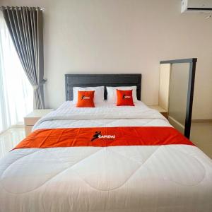 a large bed with red pillows in a bedroom at Vasana by Sampai Coliving in Kejayan