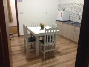 een keuken met een witte tafel en stoelen in een kamer bij Pousada Suite Master Bella Mar in Penha