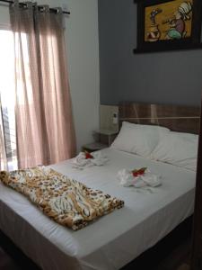 um quarto com uma cama com toalhas em Pousada Suite Master Bella Mar em Penha