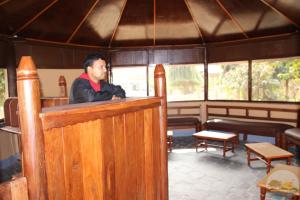 a man standing behind a bar in a tent at River View Jungle Camp in Sauraha