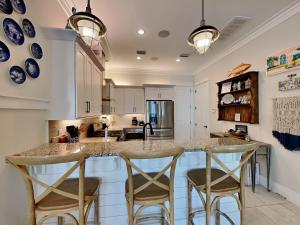 a kitchen with a counter with chairs around it at Sea La Vie In Grayton Beach in Santa Rosa Beach