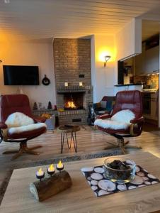 Ferienwohnung Joschko في وينتربرغ: غرفة معيشة مع كرسيين ومدفأة