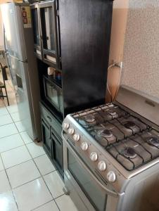 a kitchen with a stove and a refrigerator at Casa Puerta del Rey Saltillo in La Aurora