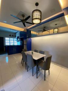 Teratak Raffa Homestay في Kampong Tebing Rabak: غرفة طعام مع طاولة وكراسي ومروحة سقف