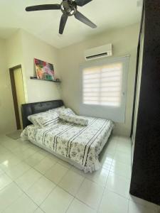 Teratak Raffa Homestay في Kampong Tebing Rabak: غرفة نوم بها سرير ومروحة سقف