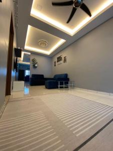 Teratak Raffa Homestay في Kampong Tebing Rabak: غرفة معيشة مع مروحة سقف وأريكة