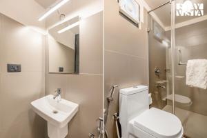 a bathroom with a toilet and a sink and a shower at StayVista at Griha Sankalpa with Mountain View, BBQ in Koroth