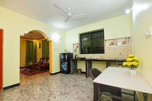 a living room with a table and a ceiling fan at Margaritas Residency in Benaulim