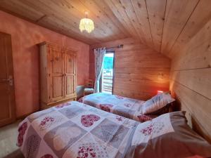 a bedroom with two beds in a wooden cabin at Chalet chaleureux face aux pistes, proche Gérardmer, idéal pour famille, balcon et terrasse - FR-1-589-182 in Ban-sur-Meurthe-Clefcy