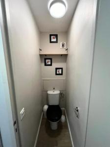 a small bathroom with a toilet with three pictures on the wall at Résidence Plagne Lauze - maeva Home - Appartement 2 Pièces 5 Personnes - Prestige MAE-4334 in Mâcot La Plagne