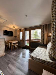 a bedroom with a bed and a table and a desk at Résidence Plagne Lauze - maeva Home - Appartement 2 Pièces 5 Personnes - Prestige MAE-4334 in Mâcot La Plagne