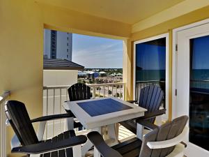 a table and chairs on a balcony with a view at Boardwalk #787 in Gulf Shores