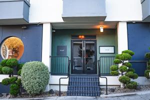 a blue and white building with a door and bushes at Kimpton Hotel Enso by IHG in San Francisco