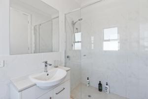 Un baño blanco con lavabo y ducha. en 4-13 Central Dr Victor Harbor-No Linen Included, en Victor Harbor 25 fotos más