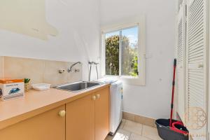 a kitchen with a sink and a mop next to a window at Greenwich Luxury near WharfTrainCBD steps to Sea in Sydney +32 photos