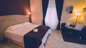 レッジョ・ディ・カラブリアにあるB&B Civico 46のベッドと椅子付きのホテルルーム
