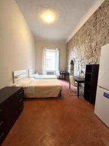 a bedroom with a bed and a stone wall at Residenza del Capitano in Siena