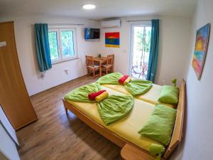 sypialnia z 2 łóżkami i zielonymi poduszkami w obiekcie Apartments Different Colours w mieście Šilo