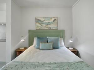 a bedroom with a large bed with blue pillows at Blue on Blue Superior Studio Room 1241 in Nelly Bay +8 photos