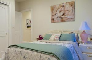 a bedroom with a bed and a lamp and a painting at Little Paradise with Sauna Garden near Downtown in Saratoga