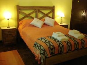 - une chambre avec un lit et des serviettes dans l'établissement Las Acacias - Posada de Campo, à Villa General Belgrano